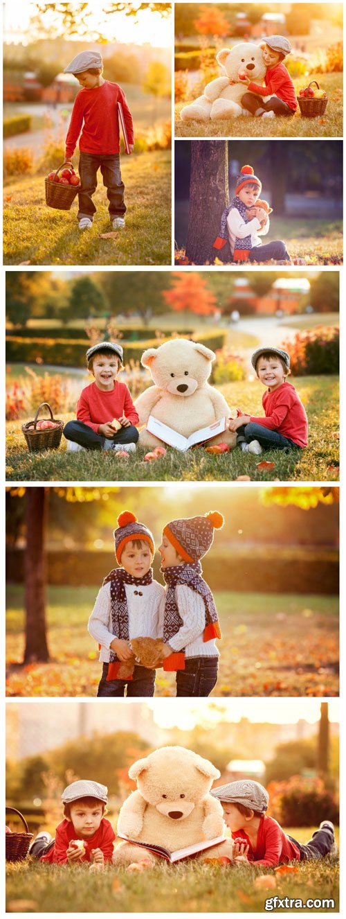 Two adorable little boys with teddy bear in the park