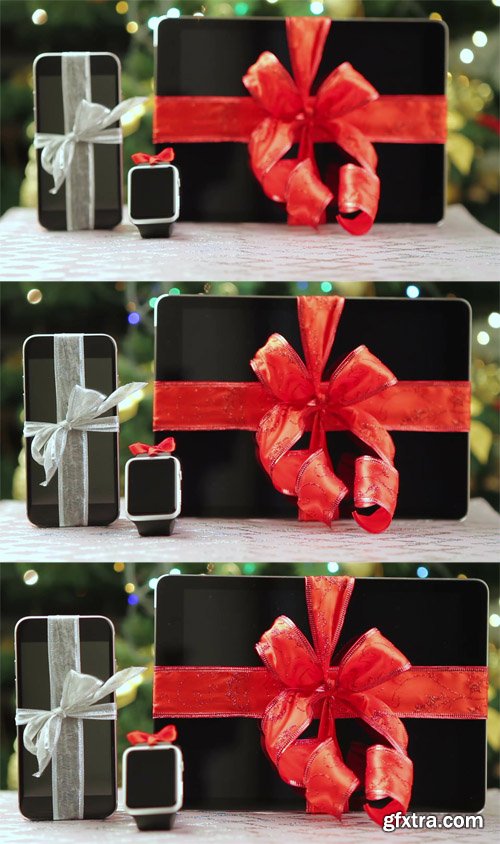 Tablet pc, smartphone and smartwatch as gifts in front of Christmas tree with lights