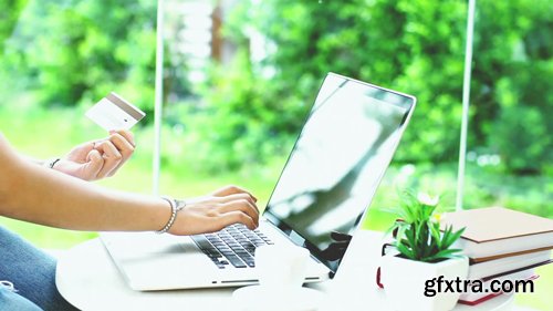 Young Asian Teenage girl having a relaxing time in a coffee shop using a laptop computer to buy products Young Asian Teenage girl having a relaxing time in a coffee shop using a laptop computer to buy products