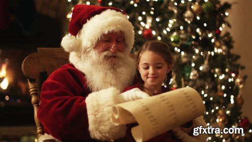 Santa Claus reading a list with a girl on his lap Santa Claus reading a list with a girl on his lap