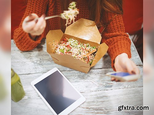 Woman Using Smartphone and Tablet While Eating Takeout Mockup 220158404 Woman Using Smartphone and Tablet While Eating Takeout Mockup 220158404