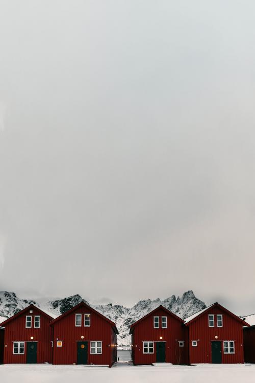 Row of red cabins on a snowy coast of Sakrisoy island, Norway - 2256899