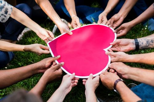 Group of people holding a pink heart icon - 537913