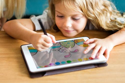Little girl coloring on a tablet - 539087