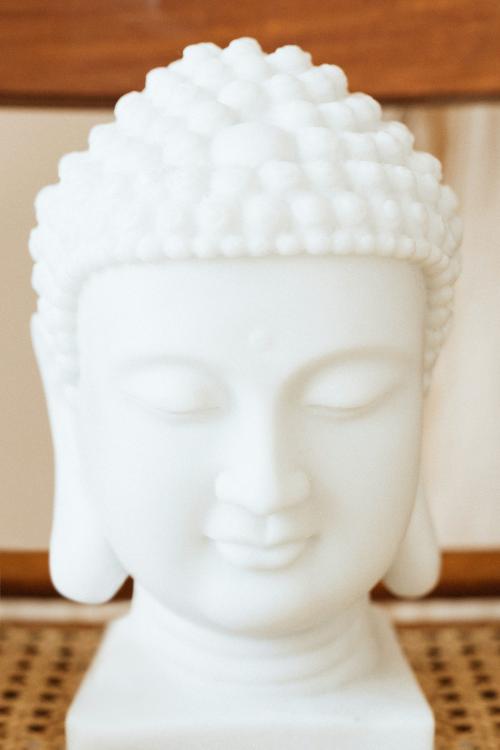 White ceramic Buddha head statue on a wooden chair - 2282153