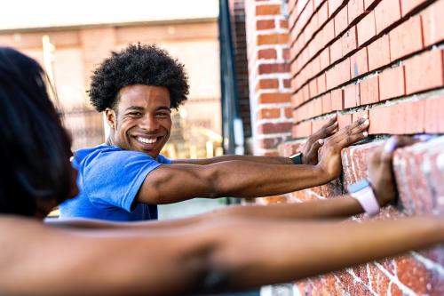 Sporty couple stretching against a brick wall - 2041707