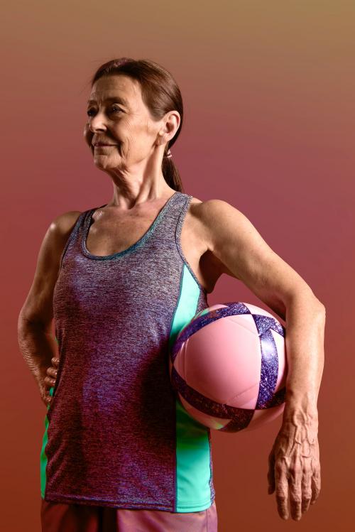 Sporty old lady in sports outfit with a medicine ball - 2224867