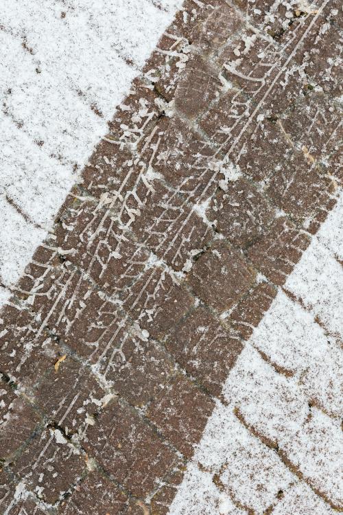 Skid marks on a an icy cobblestone road background - 2255802