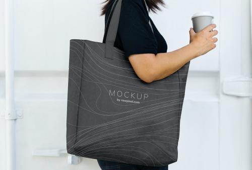 Woman carrying a black shopping bag mockup - 502817