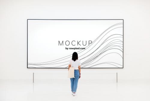 Woman at an exhibition looking at an art piece mockup - 502819