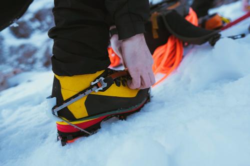 Man walking in the snow with crampons - 2097690