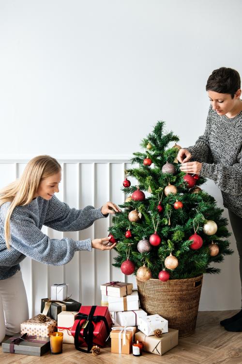 Woman decorating a Christmas tree with ornaments - 1231811