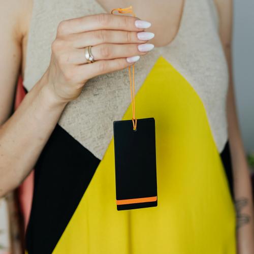 Woman in a yellow dress holding a black cloth brand tag - 1207880