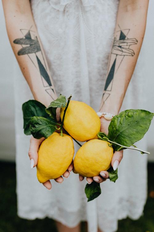 Tattooed hands holding fresh lemons - 1207987