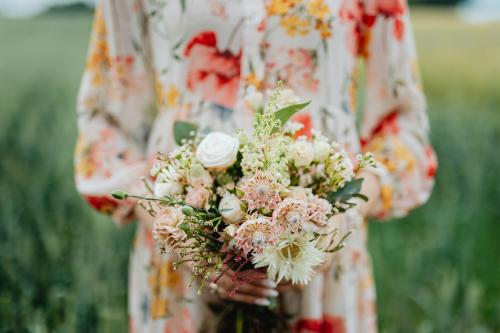 Woman in a floral dress holding a flower bouquet - 1208011