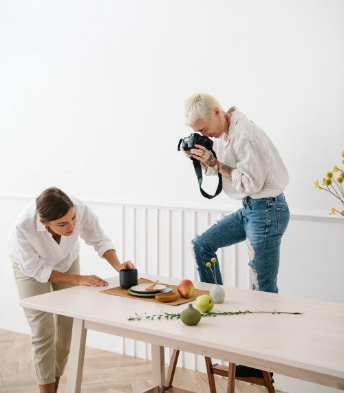 Blogger photographing the plate decor on the dining table - 1212746