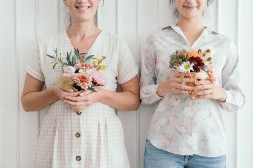 Mother and daughter holding flowers in ice cream cones - 1207377