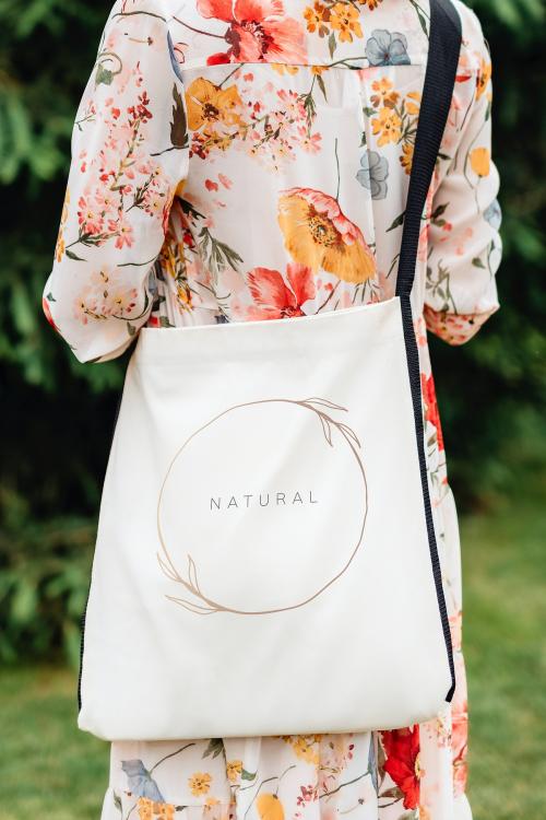 Woman in a floral dress with a tote bag - 1207938
