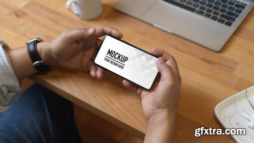 Hand holding smartphone mockup and christmas decorations