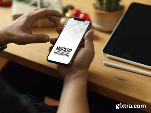 Hand holding smartphone mockup and christmas decorations