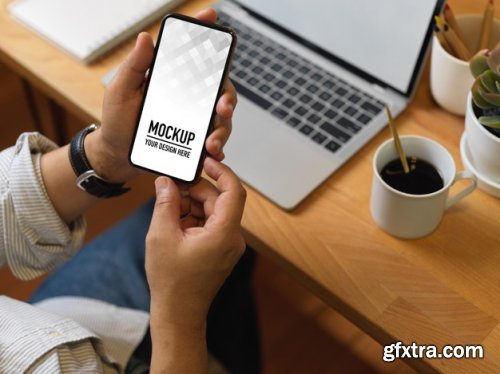 Hand holding smartphone mockup and christmas decorations