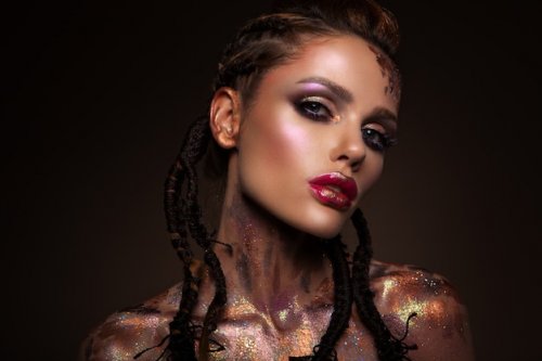 Fashion model with bright makeup and colorful glitter