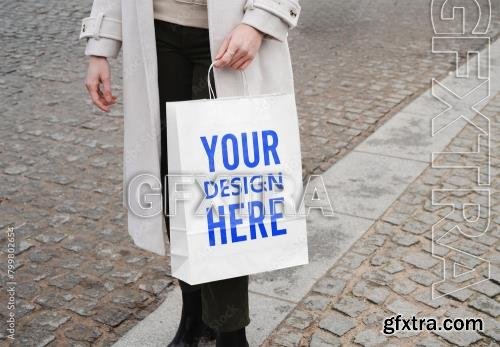 Mockup of woman with customized paper shopping bag 799802654